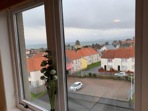 a window with a view of a city with a car at Superb One Bedroom Getaway in Dysart Kirkcaldy in Kirkcaldy