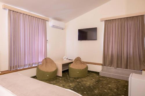 a room with two chairs and a table and a tv at Colette Hotel in Yerevan