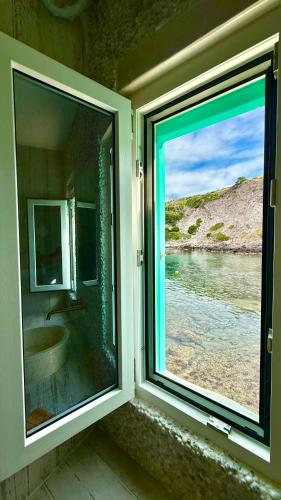 a bathroom with a window with a view of the water at Milos Boathouse-Between2seas Boutique in Areti