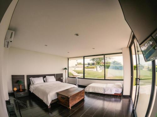 a bedroom with two beds and a large window at La Montaña Mágica in Montenegro