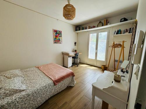 a bedroom with a bed and a desk and a window at Villa Arles Trinquetaille in Arles
