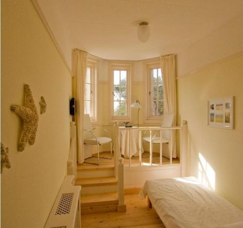 a bedroom with a bed and a room with a table at Landgoed Huize Glory in Bergen aan Zee