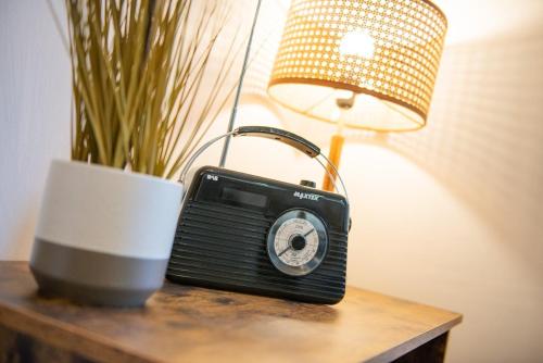 a black radio sitting on a table next to a lamp at Charming 2 Bedroom Flat in the Heart of Kirriemuir in Kirriemuir