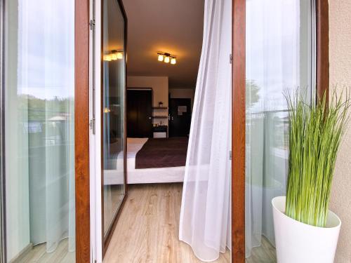 a sliding glass door with a plant in a vase at Villa Sarema in Chłopy