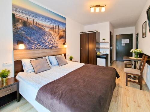 a bedroom with a bed and a painting of a beach at Villa Sarema in Chłopy
