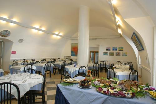 un salón de banquetes con mesas y sillas y platos de comida en Hotel Elisa - Spiaggia Privata Inclusa, en Peschici