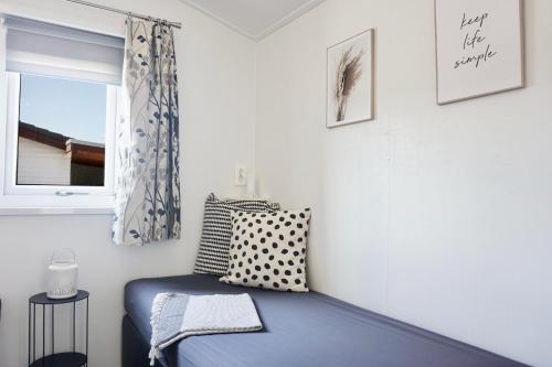 a bedroom with a blue bed and a window at Ferienhaus Ufergeheimnis am Gülser Moselbogen I 2 SZ I 5 Gäste I Badebucht I Grill I Garten in Koblenz