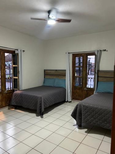 une chambre avec deux lits et un ventilateur de plafond dans l'établissement Apartamentos en el centro con vistas a la iglesia y al andador, à Calvillo