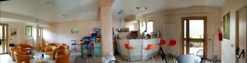 a living room with orange chairs in a room at Hotel Aquila in Scoppito