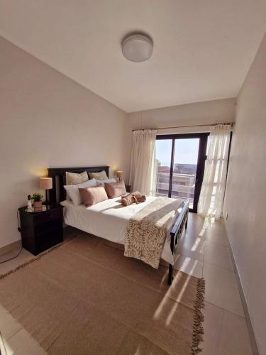 a bedroom with a large bed and a large window at 6 on Sunset Valley in Khomas Region