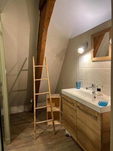 La salle de bains est pourvue d'un lavabo et d'une échelle en bois. dans l'établissement Le Loft by Le Petit Pressoir, à Saint-Gatien-des-Bois