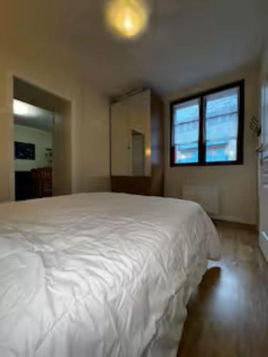 un grand lit blanc dans une chambre avec une fenêtre dans l'établissement Chez Cyril et Angelique, à Cauterets