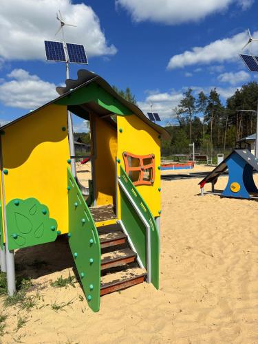 a playground with a play house with a solar roof at Urocze Roztocze Jacnia - domek 1 in Jacnia