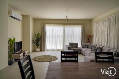 een woonkamer met een bank en een tafel bij VIZIT Hacienda Bay in El Alamein