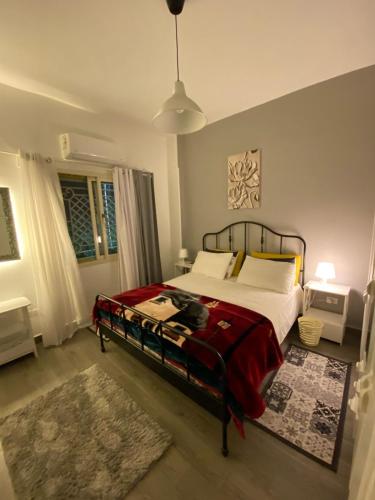 a bedroom with a bed with a red blanket at ToTi House in Banī Ghālib