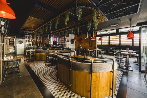 a restaurant with a bar with tables and chairs at Hotel 219 Budva in Budva