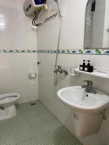 a bathroom with a sink and a toilet at Full House Cát Bà in Cat Ba