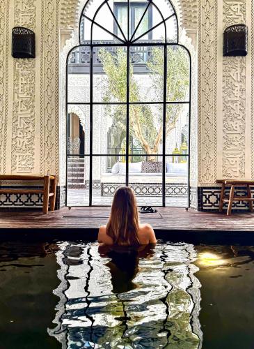 マラケシュにあるリヤド ケレディンの建物内の水たまりに座っている女性