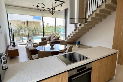 a kitchen and living room with a spiral staircase at Elysian Blue villa 4 in Paphos City