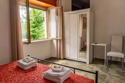 a bedroom with a bed and a window and a chair at Villa Olimpia Guest House in Finocchito