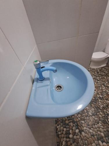 a blue sink in a bathroom with a toilet at Rinjani Koceng Bungalow in Tetebatu