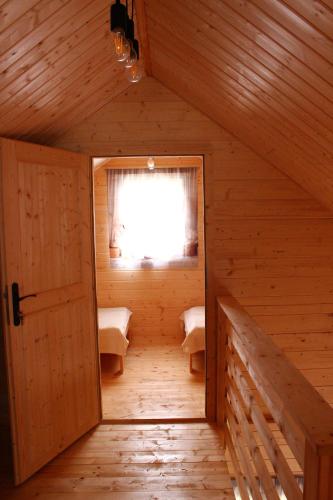 an attic room with a door and a window at Domki u Rybaka Wapnica in Wapnica