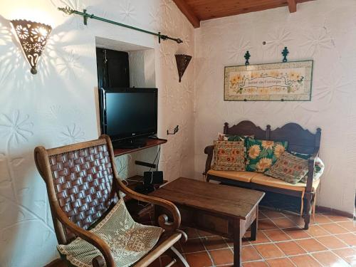 a living room with a tv and chairs and a table at Heaven House in Sesimbra