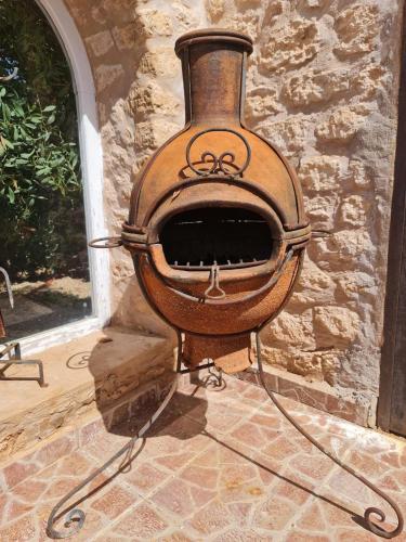 a wood fired oven sitting next to a stone wall at Villa Riad Ahlam in Sidi Kaouki