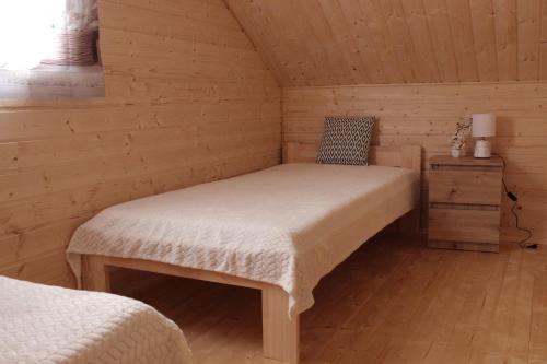 a bedroom with a bed in a wooden cabin at Domki u Rybaka Wapnica in Wapnica