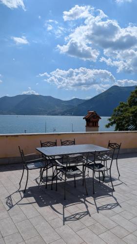 a table and chairs with a view of the water at Attico Vittoria in Marone