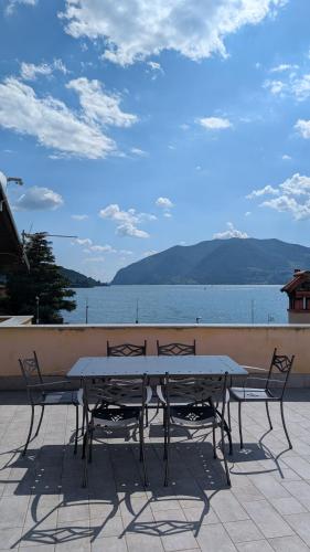 a table and chairs with a view of the water at Attico Vittoria in Marone