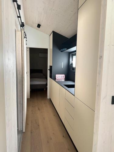 a hallway with a kitchen with a bed in the background at Camp O Lake Haus am See in Villach