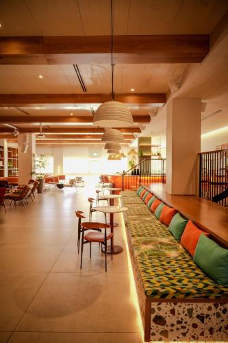 a lobby with a long bench with tables and chairs at Prima Music Hotel in Eilat
