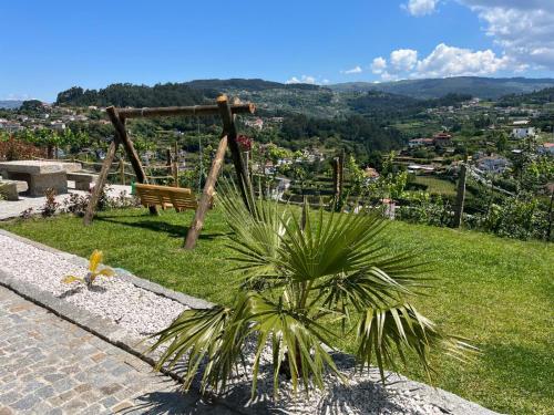 a park bench on a hill with a palm tree at CRASTO PAYVA DOURO NATURE in Castelo de Paiva