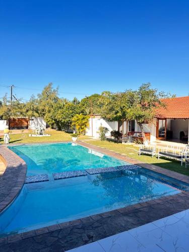 a large swimming pool in front of a house at Little Getaway in Marracuene in Fombeni
