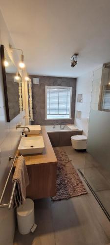 a bathroom with a sink and a toilet and a tub at Casa del Breda in Breda