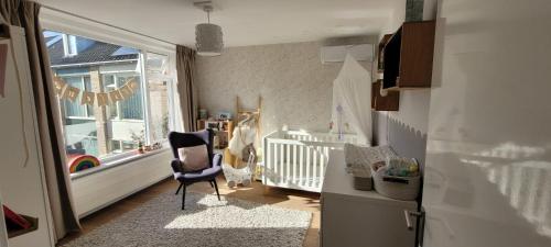 a baby room with a chair and a crib at Casa del Breda in Breda