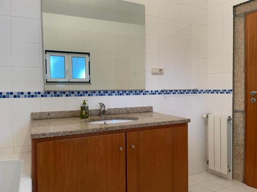 a bathroom with a sink and a mirror at Casa dos castanheiros in Ponte de Lima