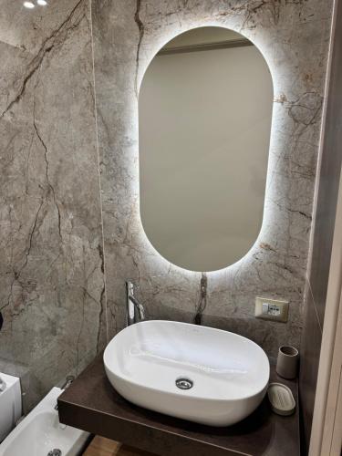 a bathroom with a white sink and a mirror at HERMES Luxury Home in Agrigento