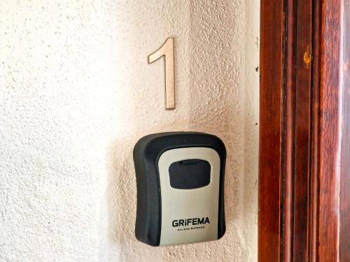 a switch on a wall with a cell phone on it at Il Caracolo Rooms in La Maddalena
