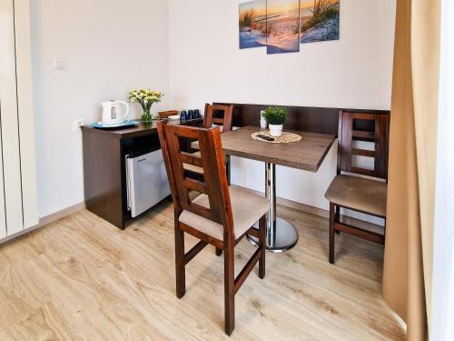 a dining room table with chairs and a desk at Villa Sarema in Chłopy