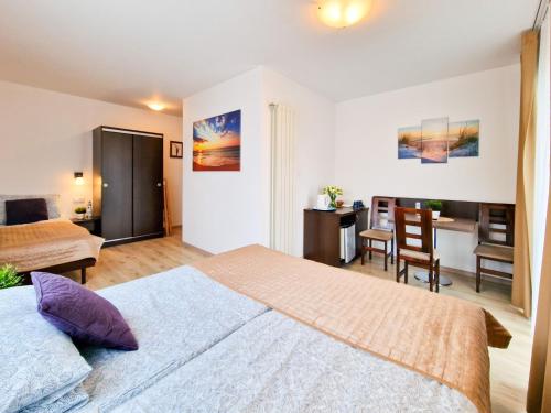 a bedroom with a large bed and a desk at Villa Sarema in Chłopy