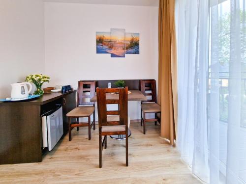 a kitchen and dining room with a table and chairs at Villa Sarema in Chłopy
