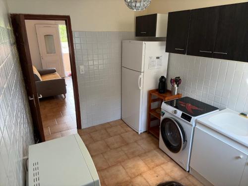 une cuisine avec un réfrigérateur et une machine à laver dans l'établissement Joli T2 dans villa, à Corte
