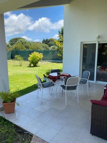 a patio with a table and chairs and a view of a yard at Rianna House in Theologos