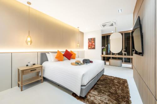 a bedroom with a white bed and a television at New 3BR Private Pool Villa with 5 Stars Resort Service in Rawai Beach