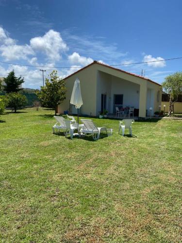 a group of chairs and an umbrella in a yard at Rianna House in Theologos