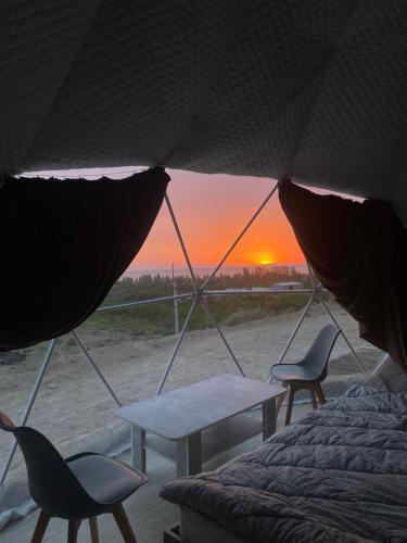 a room with a table and chairs and a sunset at Keremet in Tossor