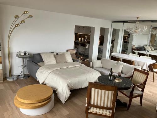 une chambre avec un lit, une table et un canapé dans l'établissement Vue, espace & confort Appartement 2 chambres avec terrasse & parking, aux portes de Paris, à Puteaux