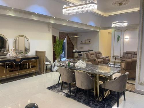 a large living room with a table and chairs at modern villa with coverable pool sheik zayed in Sheikh Zayed